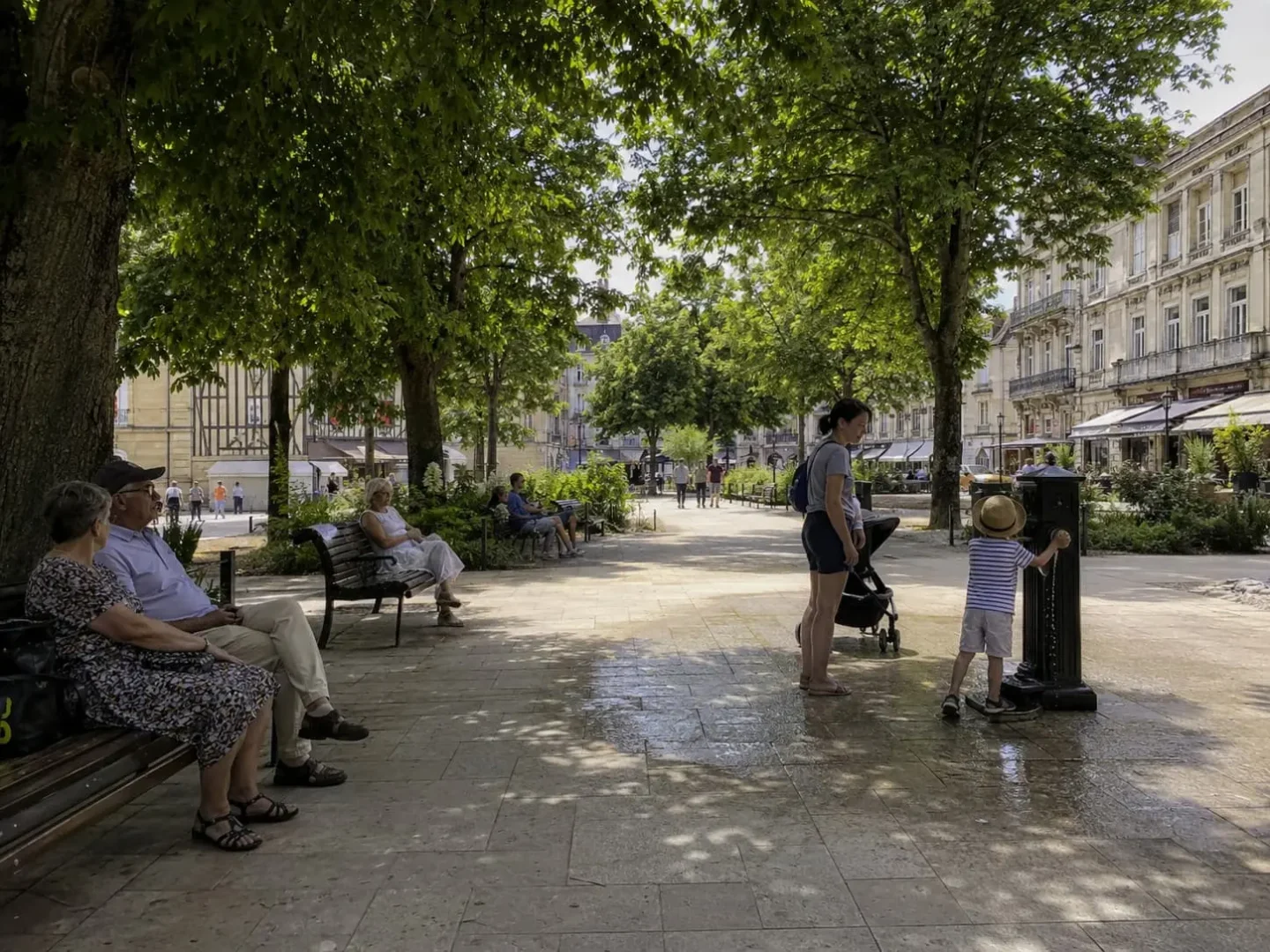 Place arborée en ville avec fontaine d’eau, zones ombragées et habitants se protégeant de la chaleur dans le Grand Est.